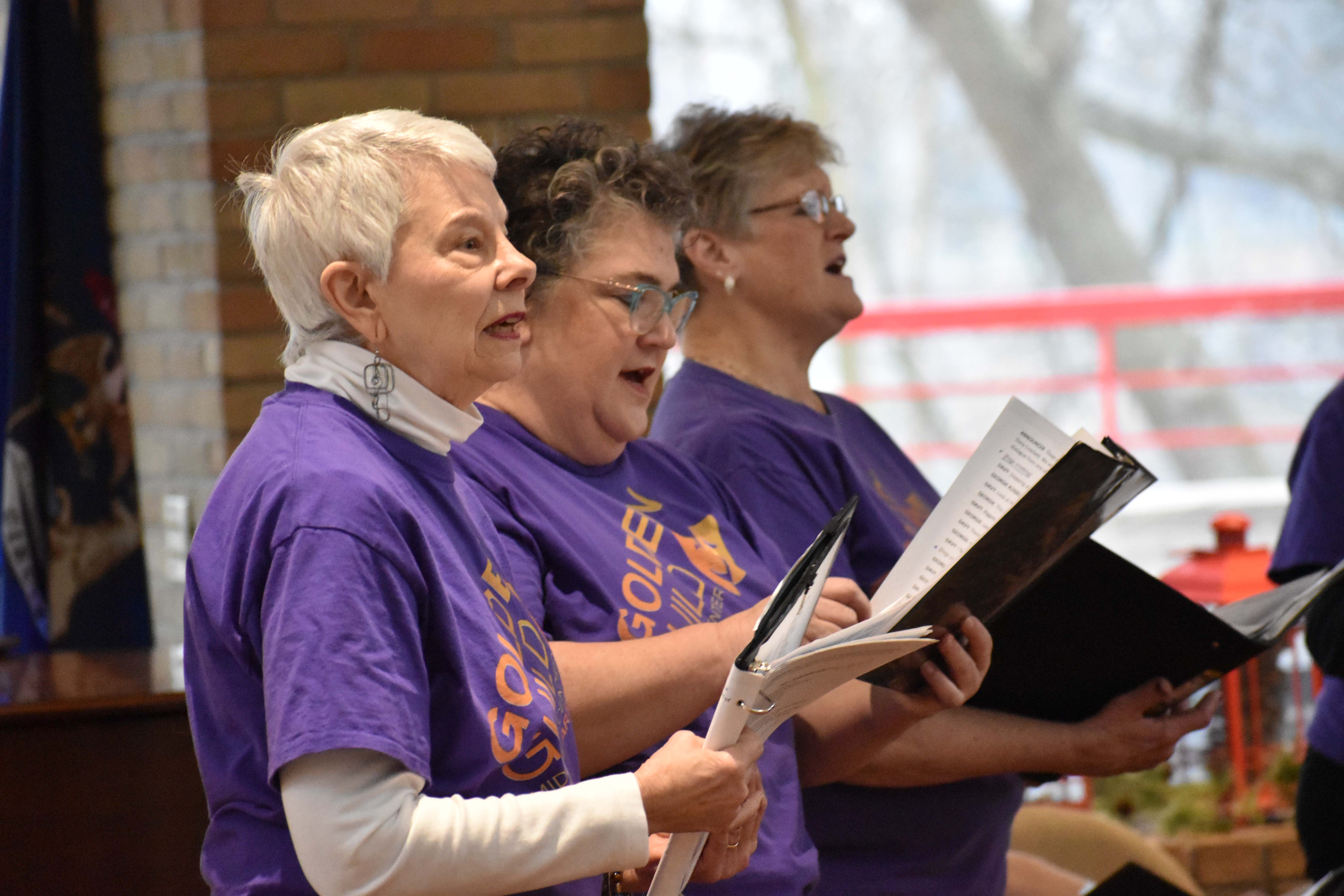 Golden Guild singers performing with music folders.