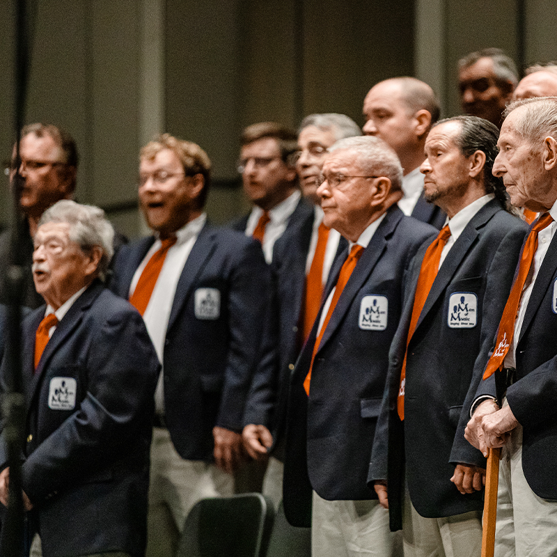 Men of Music singing together in performance.