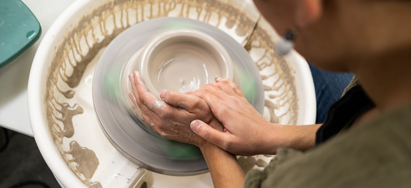 Wet clay being shaped on a pottery wheel.