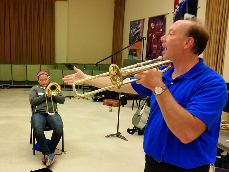 Teacher teaching students how to play trombone