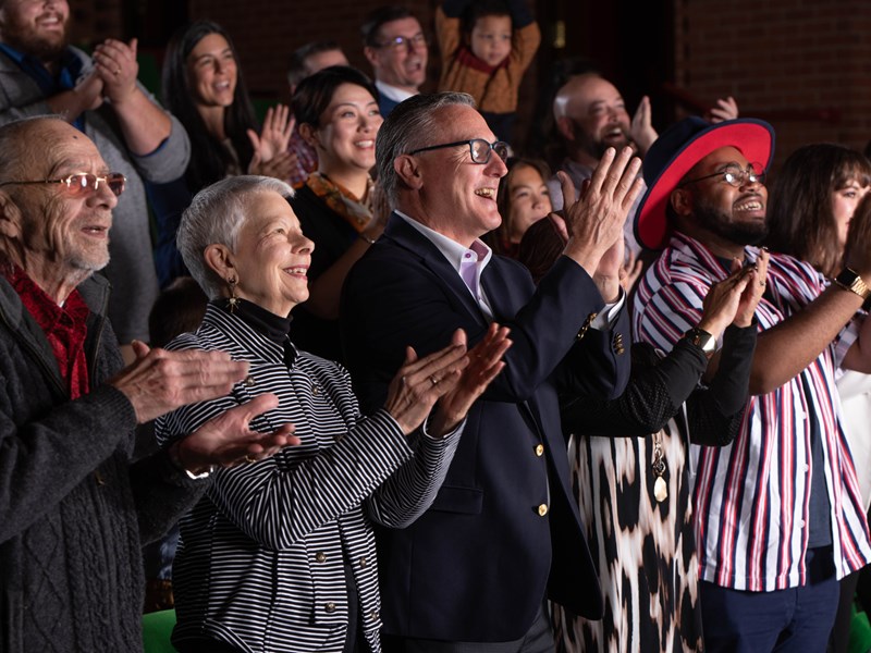 Audience members in the Little Theater applauding
