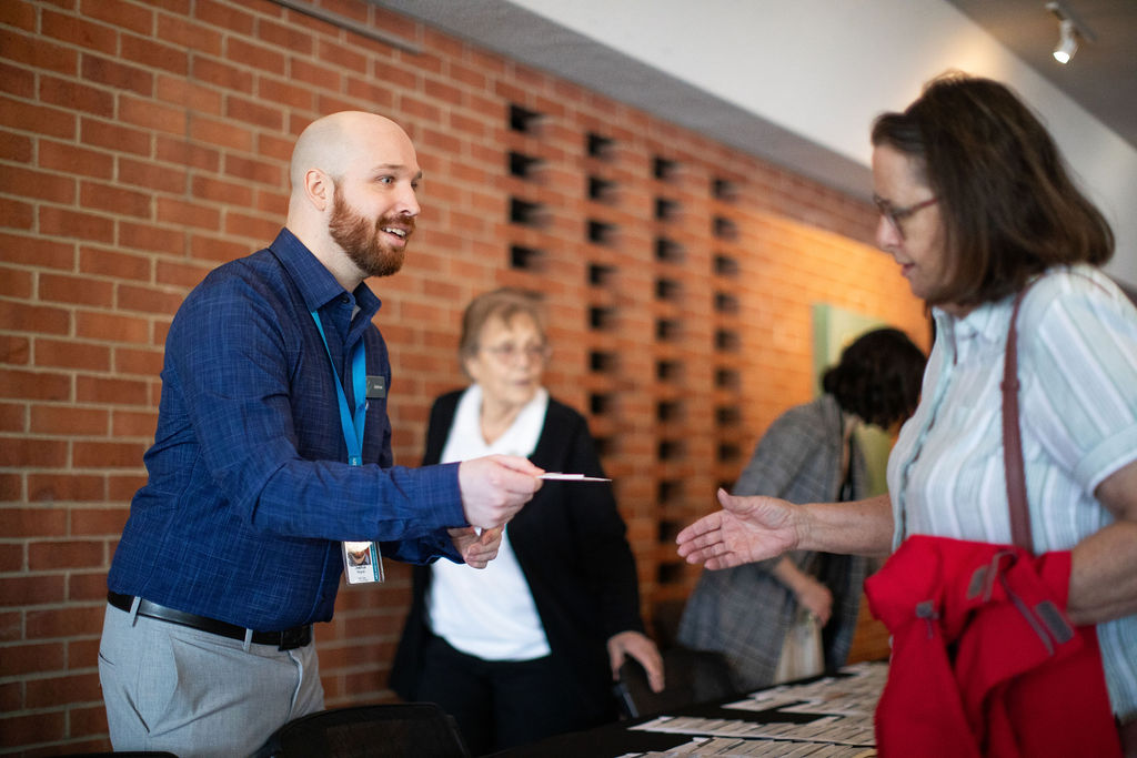 Smiling man handing a ticket to a Center patron